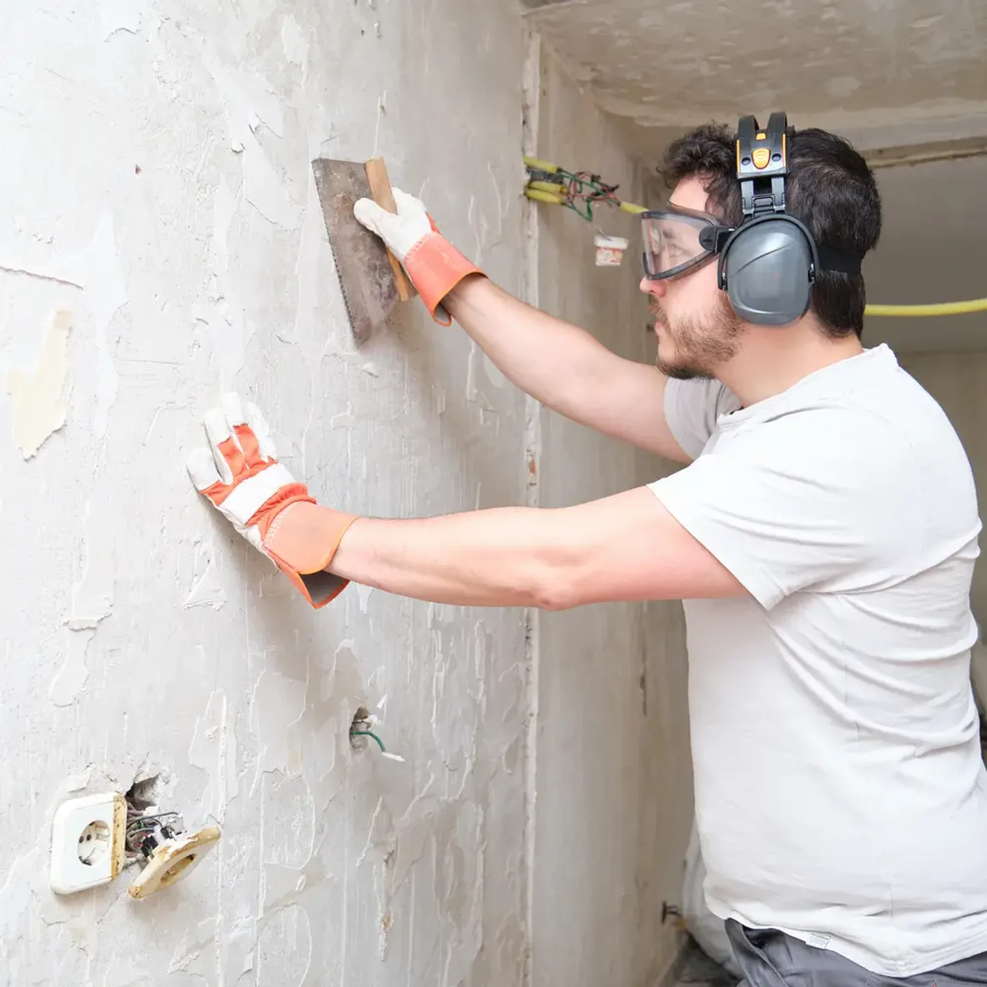 Handwerker zieht frischen Putz mit der Kelle an einer Innenwand ab